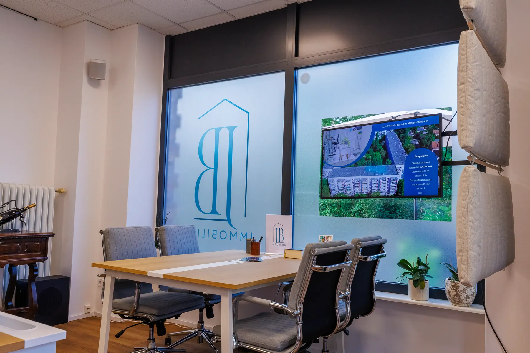 Meeting table at the JB Immobilien office with a screen showing an exposé
