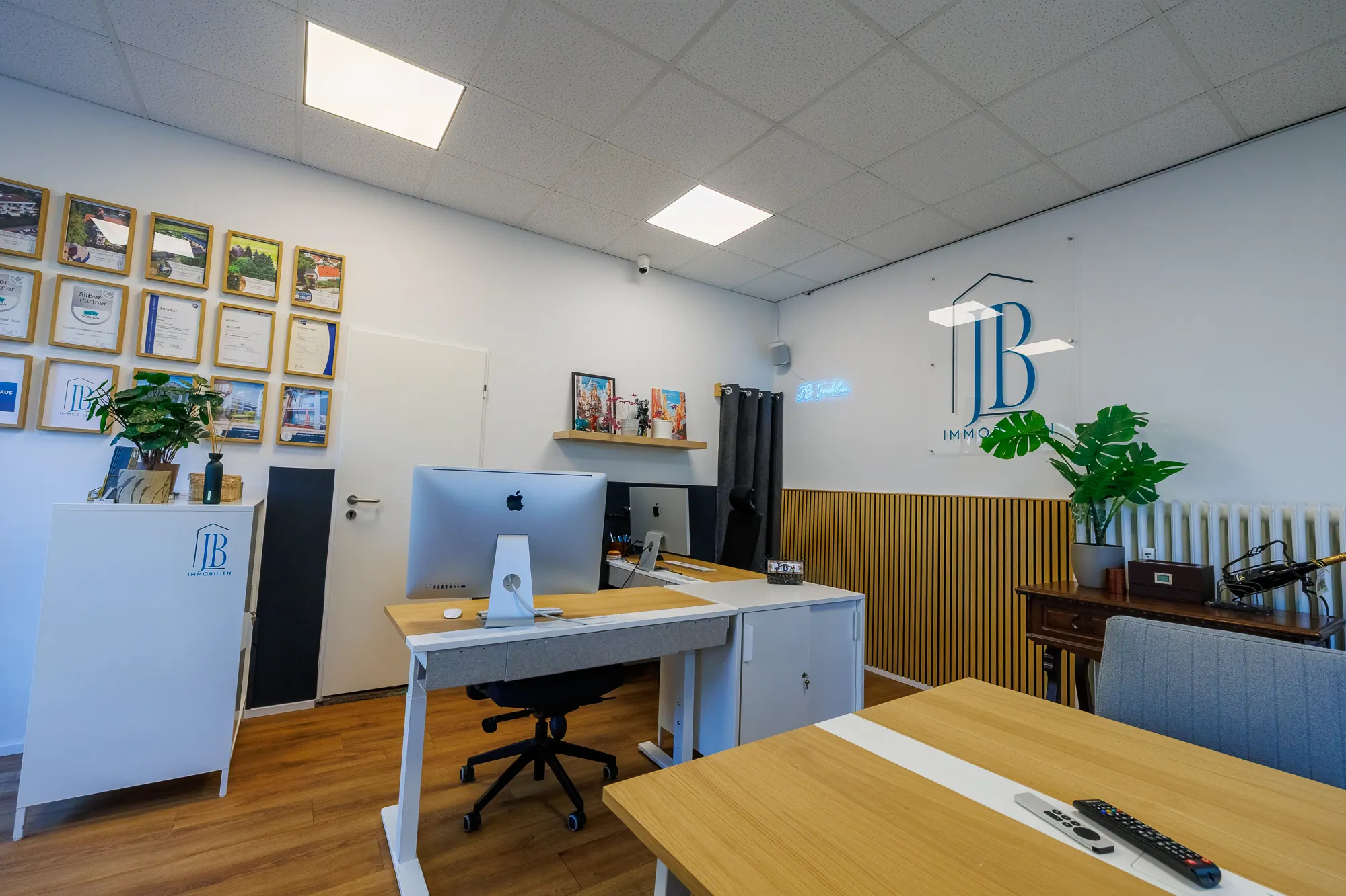 Empfang im Büro von JB Immobilien in der Albrechtstraße 48: Logo an der Wand, Referenzen im Rahmen